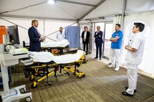 Koning Willem Alexander in gesprek met zorgpersoneel Koning in triagetent