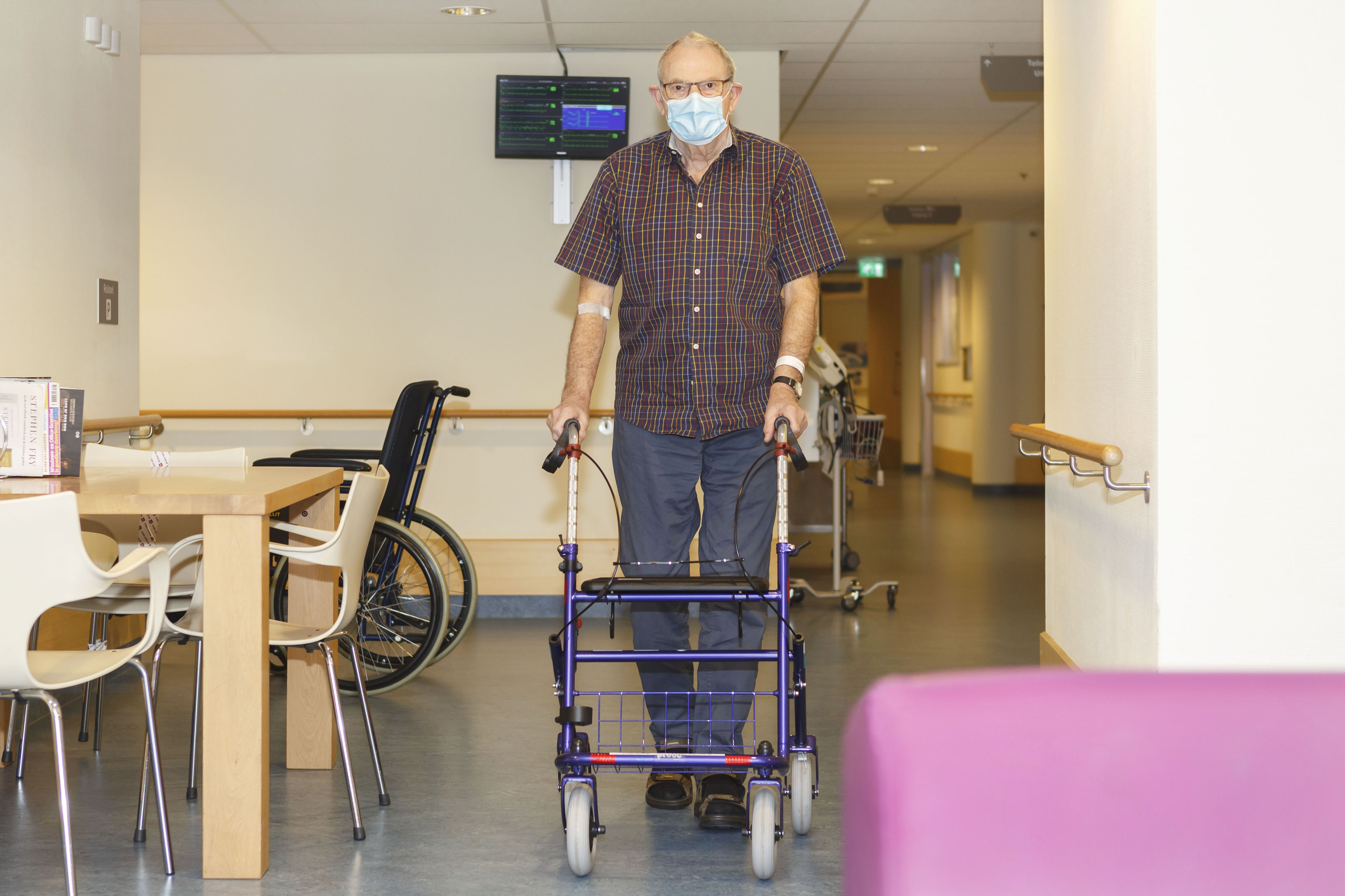 Oudere meneer in beweging in de hal van het ziekenhuis